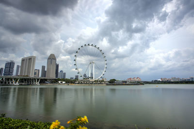 Scenic view of river by city against sky