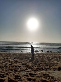 Silhouette man on beach against sky