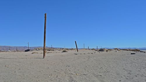 Low angle view of beach against clear blue sky