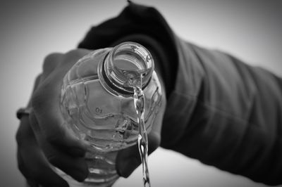 Cropped image of person pouring water from bottle