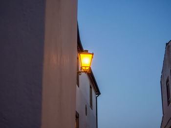 Low angle view of illuminated street light against sky