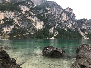 Scenic view of lake by rocky mountains against sky