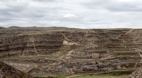 View of ruins of landscape against cloudy sky