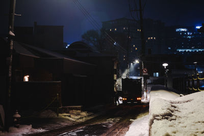 Illuminated buildings in city at night during winter