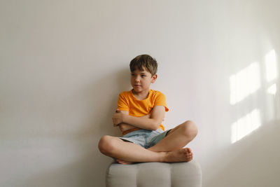 Cute boy sitting barefoot in a home. beautiful light.