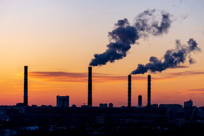 Silhouette buildings against sky during sunset