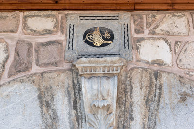 Low angle view of carving on old building wall