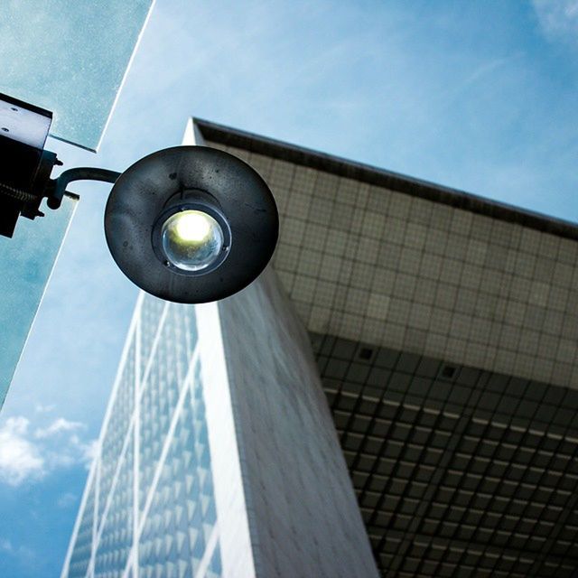 low angle view, architecture, built structure, building exterior, modern, sky, tall - high, office building, tower, city, skyscraper, building, street light, glass - material, blue, reflection, sunlight, day, directly below, no people