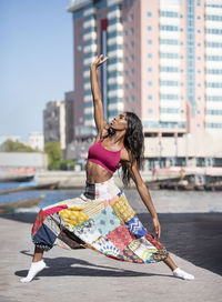 Side view of healthy woman standing on street in city