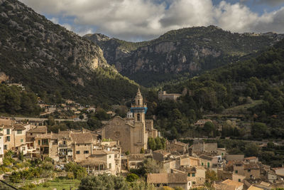 Townscape by mountains against sky