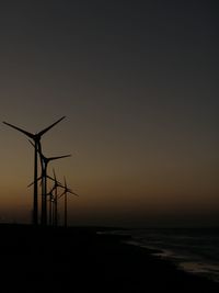 Silhouette of wind turbines on land