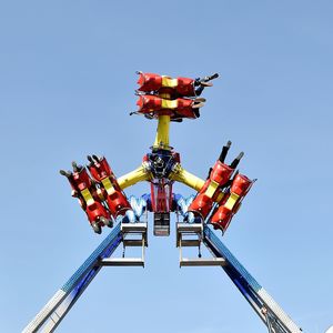 Low angle view of ride against blue sky