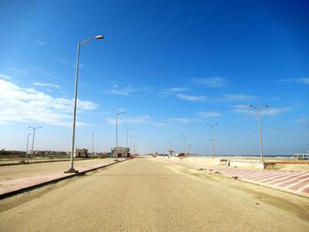 Empty road against blue sky