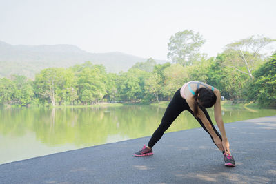 Woman stretching by lake