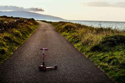 Road amidst sea against sky