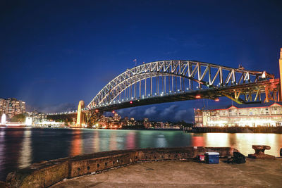 Illuminated bridge over river at night