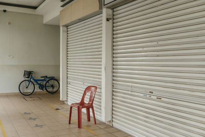Empty chair on corridor by closed shutter of store