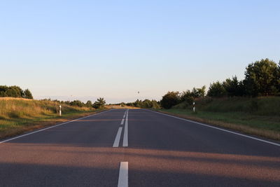 Road passing through landscape against clear sky