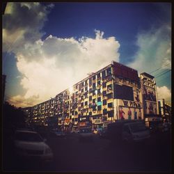 Buildings in city against cloudy sky