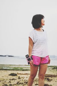 Full length of woman standing on beach against clear sky