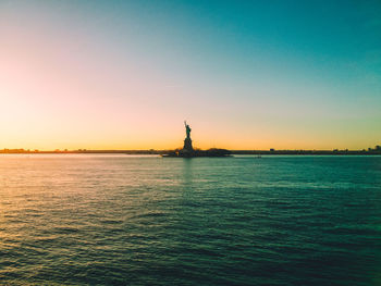 Statue of liberty in new york at sunset on a clear day