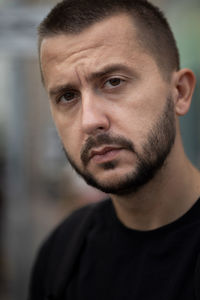 Bearded depressed person looks to a camera. portrait of sad young adult caucasian man.