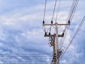 Low angle view of electricity pylon against sky