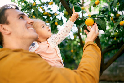 Side view of man holding fruit