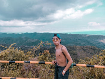 Man standing against mountains and sky