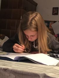 Close-up of young woman reading book at home