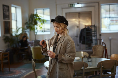 Woman igniting candles in cafe