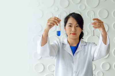 Young woman experimenting chemicals in test tubes in laboratory