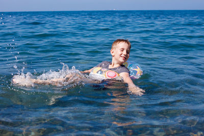 Portrait of happy boy swimming in sea