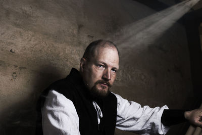 Thoughtful man sitting by wall