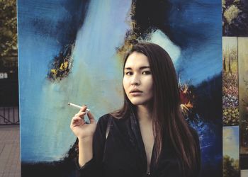 Portrait of young woman smoking cigarette