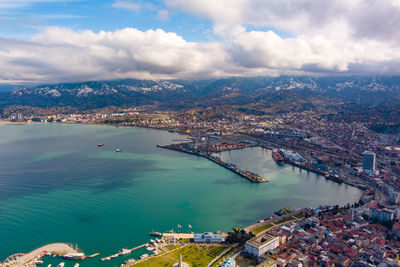 High angle view of cityscape by sea against sky