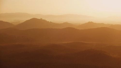 Scenic view of mountains against sky at sunset