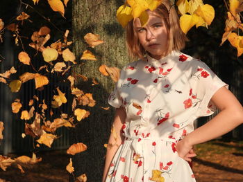 Low angle view of woman standing with leaves