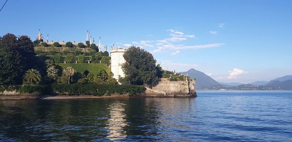 Scenic view of river by buildings against sky