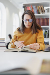 Young businesswoman using laptop while sitting at desk in library