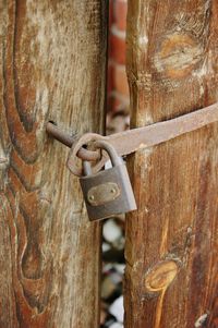 Close-up of rusty metal padlock on wooden door