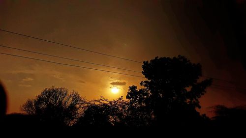 Low angle view of silhouette trees against sunset sky