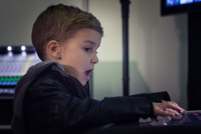 Cute boy mixing music in recording studio