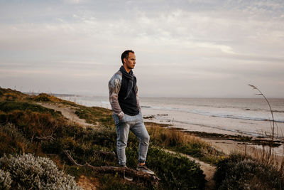 Full length of man standing on beach against sky