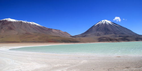 Scenic view of mountains against blue sky