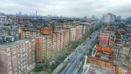 View of cityscape against cloudy sky