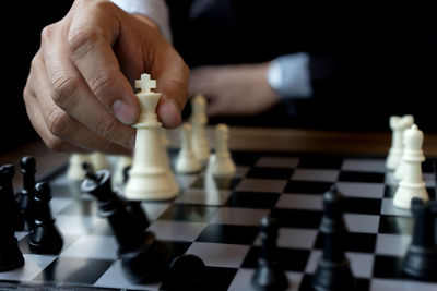 Midsection of person playing chess at home