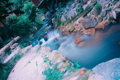 High angle view of waterfall amidst rocks in forest