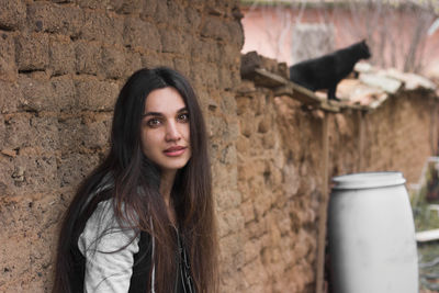 Portrait of a young woman against wall