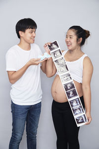 Young couple kissing against white background